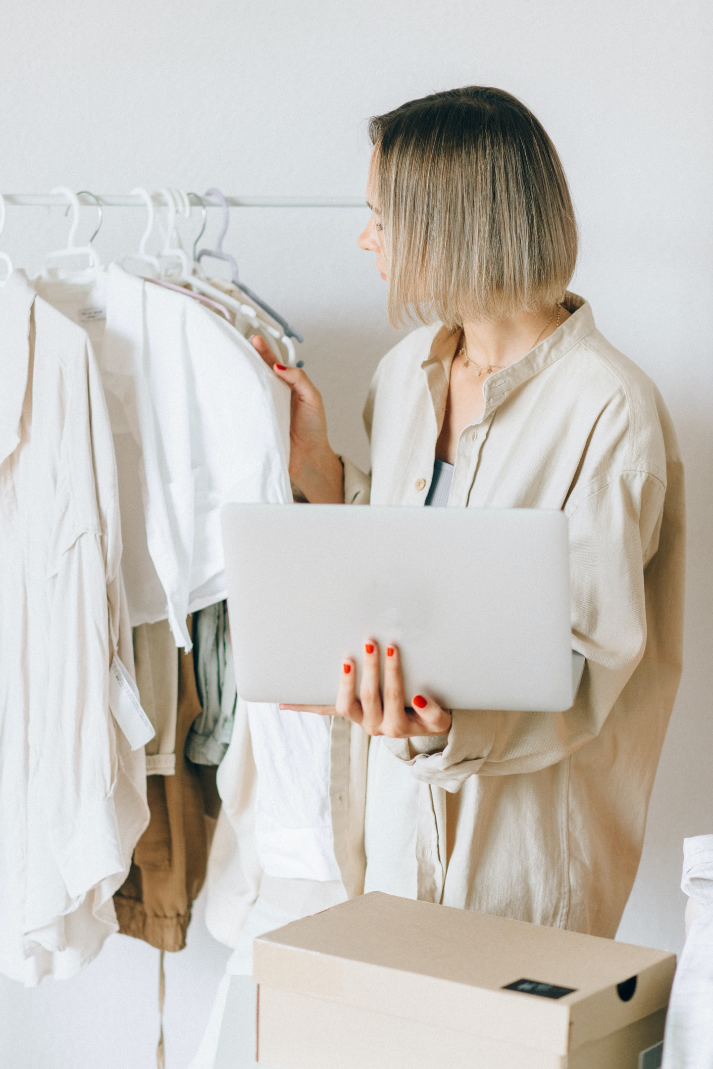 Women with a computer on her hand, looking at a clothing line.